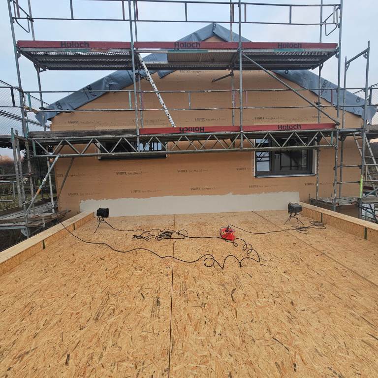 Neubau Fassade dämmen mit Holzfaser Dämmplatten, Gerüst und Fensteranschlüsse sichtbar